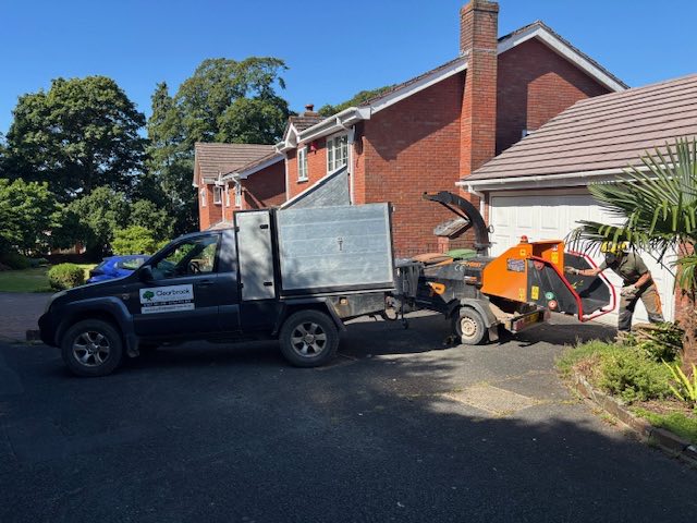 The Clearbrook Tree Services pickup and wood chipper set up on a driveway at a domestic job